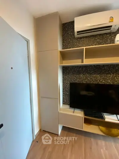 Modern living room with sleek TV unit and air conditioning, perfect for cozy urban living.