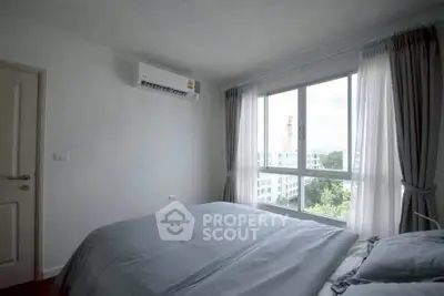 Cozy bedroom with large window and air conditioning, offering a serene view.
