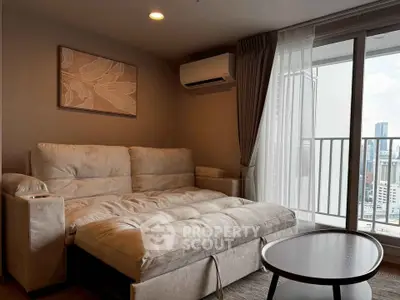 Modern living room with plush sofa and city view balcony in high-rise apartment.