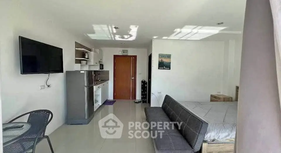 Modern studio apartment with sleek kitchen and cozy living area, perfect for urban living.