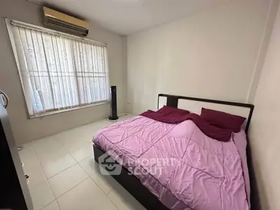 Cozy bedroom with air conditioning and large window, featuring a comfortable bed and minimalist decor.