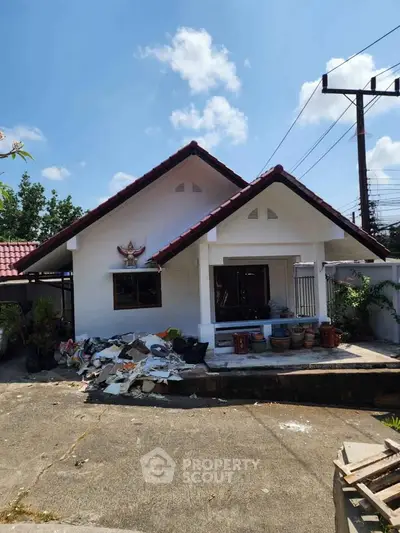 Charming single-story house with red-tiled roof and spacious front yard, perfect for family living.