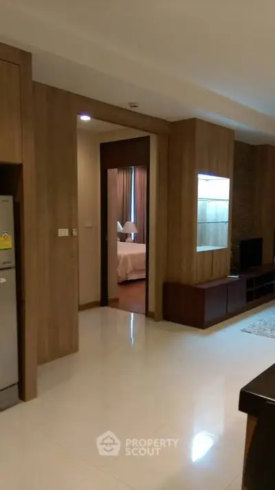 Modern apartment interior with wooden accents and view into cozy bedroom