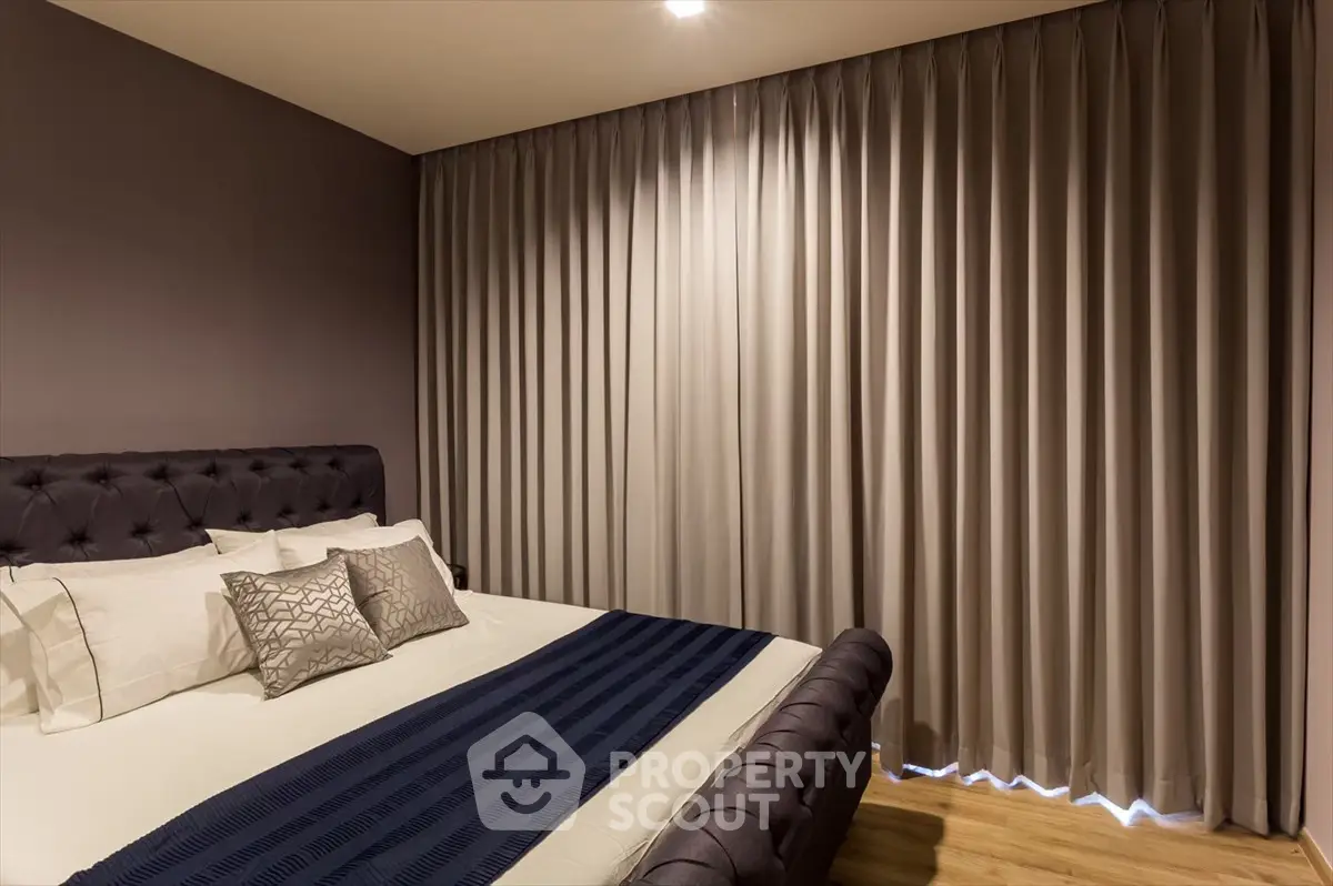 Elegant bedroom with plush bed and floor-to-ceiling curtains