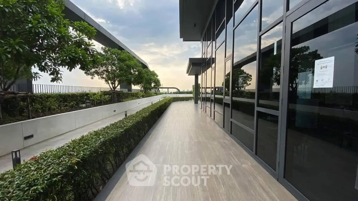 Modern building exterior with sleek glass facade and lush greenery
