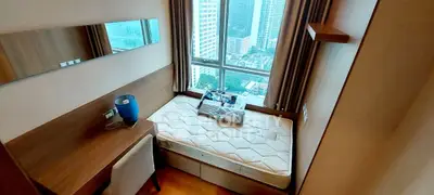 Cozy bedroom with city view, featuring a comfortable bed and a stylish desk, perfect for urban living.