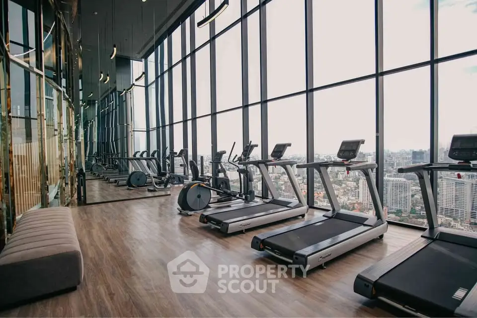 Luxurious high-rise gym with panoramic city views and modern fitness equipment.