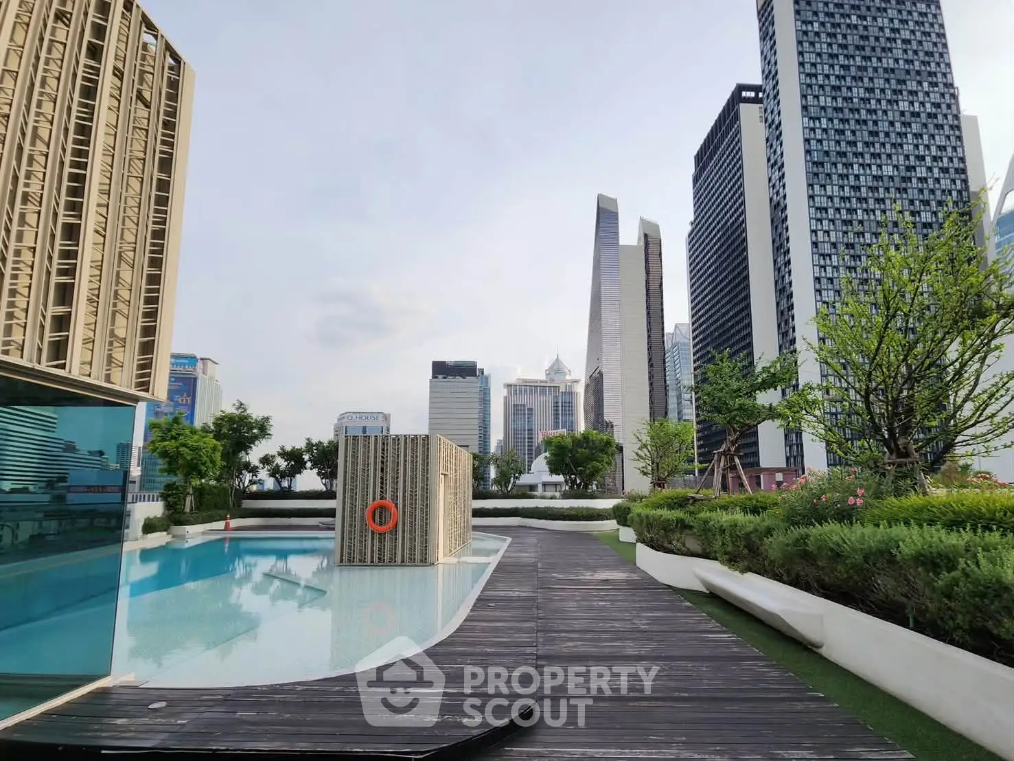 Luxurious rooftop pool with stunning city skyline views and lush greenery, perfect for urban relaxation.