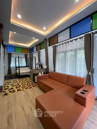 Stylish living room with modern decor and cozy seating area, featuring colorful stained glass windows and elegant lighting.