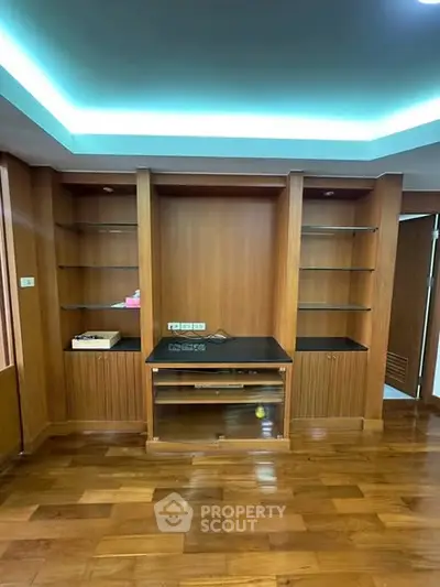 Spacious wooden interior with built-in shelves and modern lighting, perfect for stylish living.