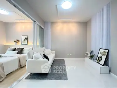 Modern open-plan living room with cozy bedroom, stylish decor, and neutral tones.