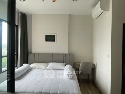 Modern bedroom with large window and air conditioning in a stylish apartment.