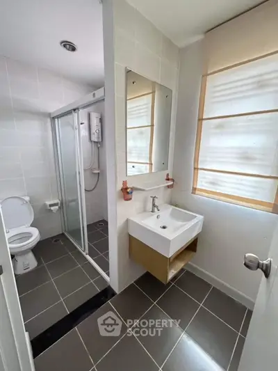 Modern bathroom with sleek design, featuring a glass shower and stylish sink.