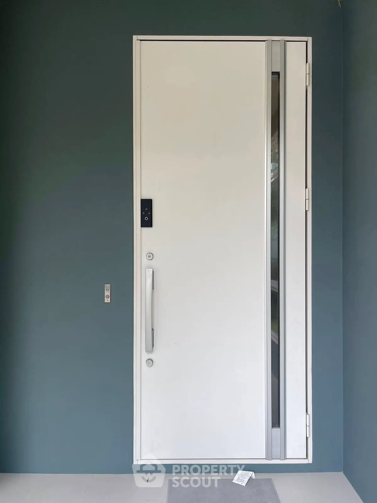 Modern white door with sleek handle on blue wall, showcasing contemporary entrance design.