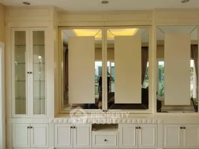 Elegant built-in living room cabinetry with mirrored panels and ample storage space.