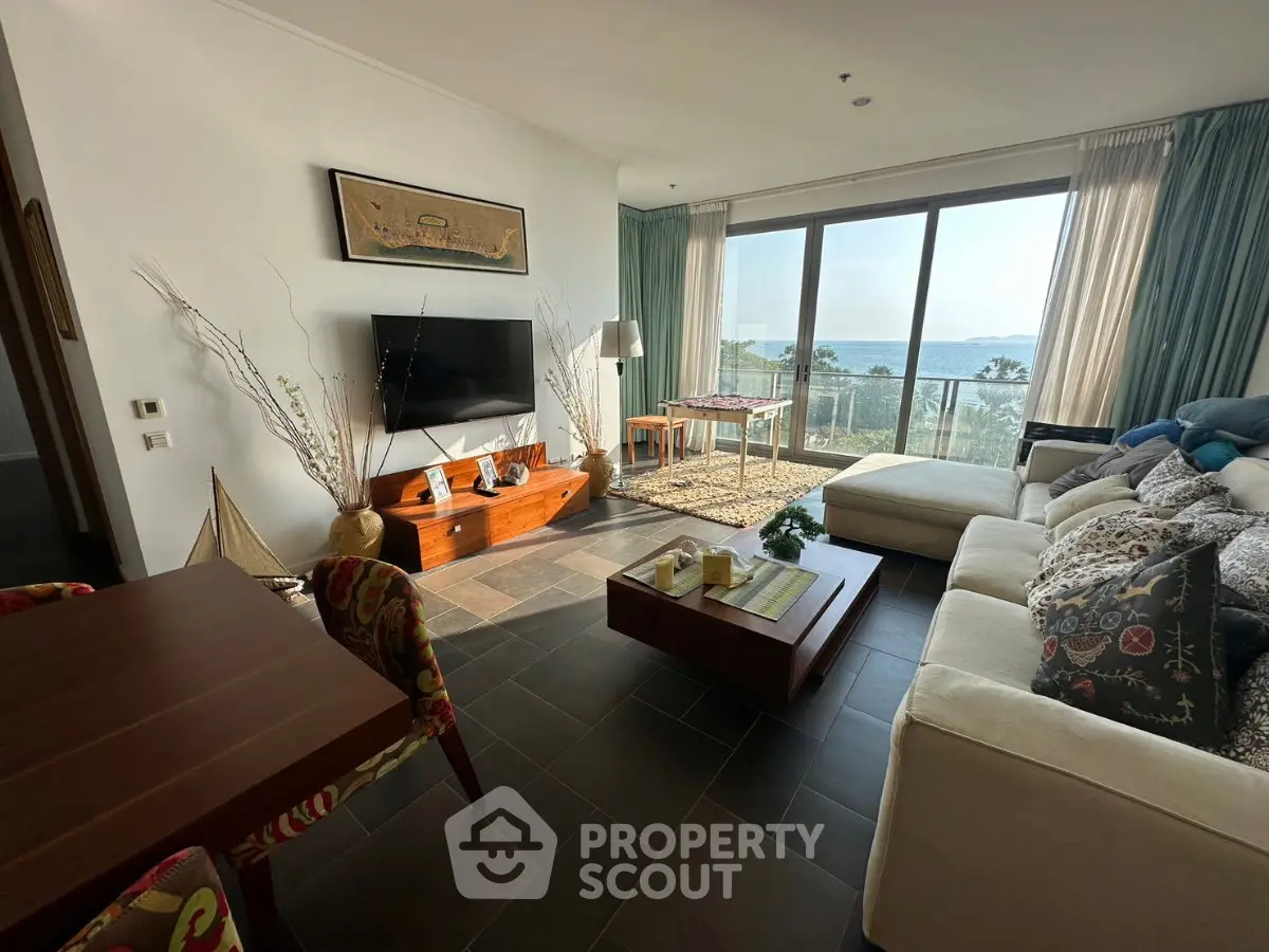 Spacious living room with ocean view, modern decor, and large windows for natural light.