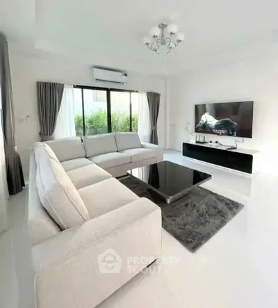 Spacious modern living room with large sectional sofa and sleek entertainment setup.