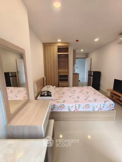 Spacious bedroom with modern furnishings and ample storage in a stylish apartment.