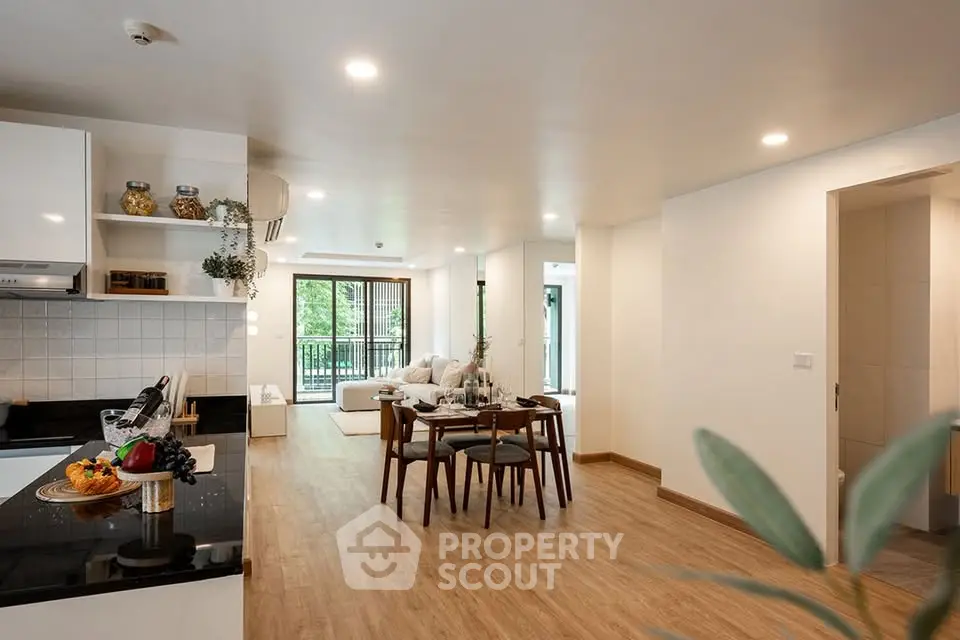 Spacious open-plan living and dining area with modern kitchen and natural light.