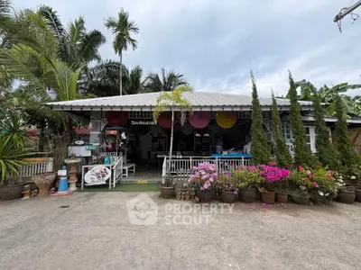 Charming tropical-style house with lush garden and inviting entrance, perfect for serene living.
