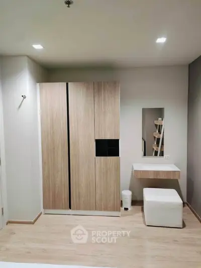 Modern bedroom with sleek wardrobe and minimalist vanity in stylish apartment.