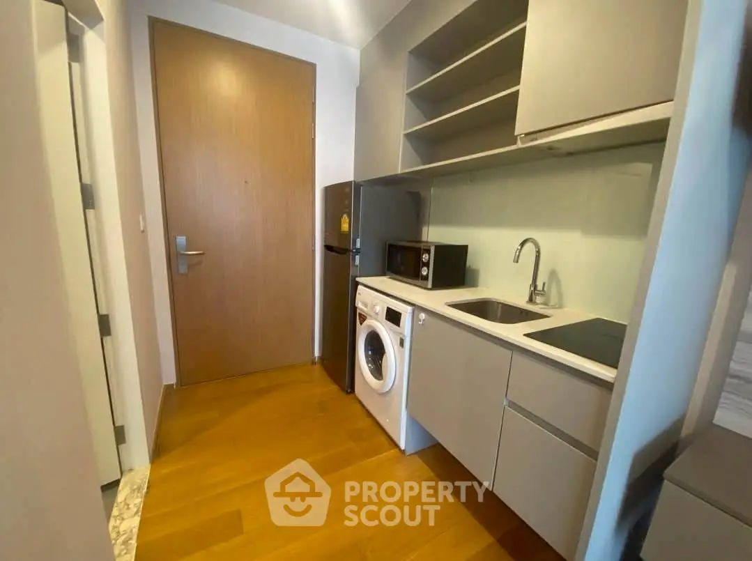 Modern compact kitchen with washing machine and sleek cabinetry