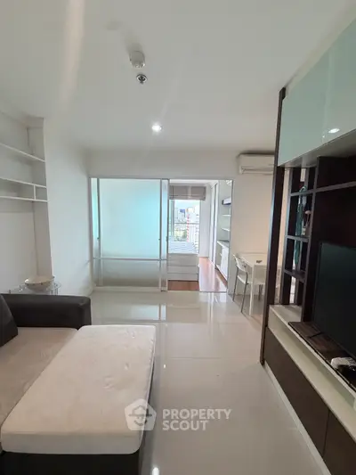Modern living room with sleek design and open layout, featuring a cozy sofa and built-in shelving.