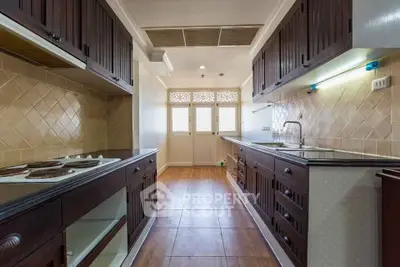 Spacious kitchen with wooden cabinets and modern appliances in a stylish home.