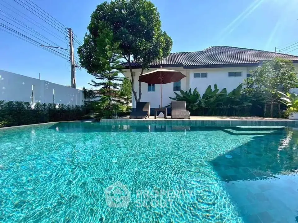 Luxurious home with sparkling pool and lush garden, perfect for relaxation and entertainment.