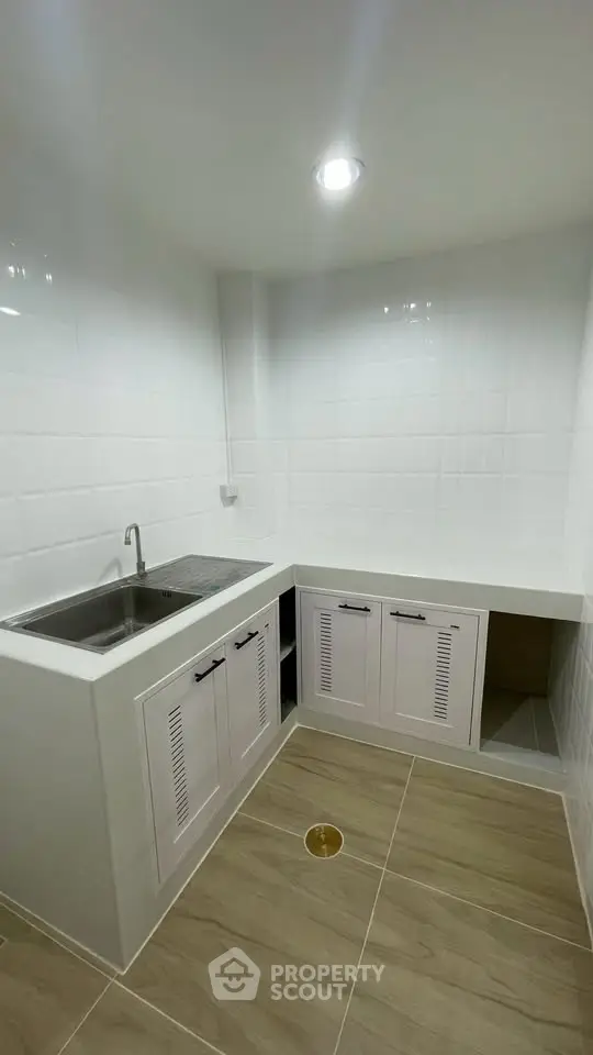 Modern kitchen with sleek white cabinets and stainless steel sink