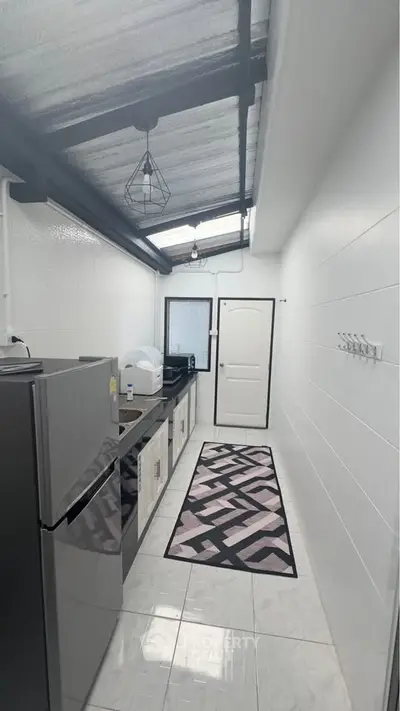 Sleek modern kitchen with skylight and stylish black and white decor.