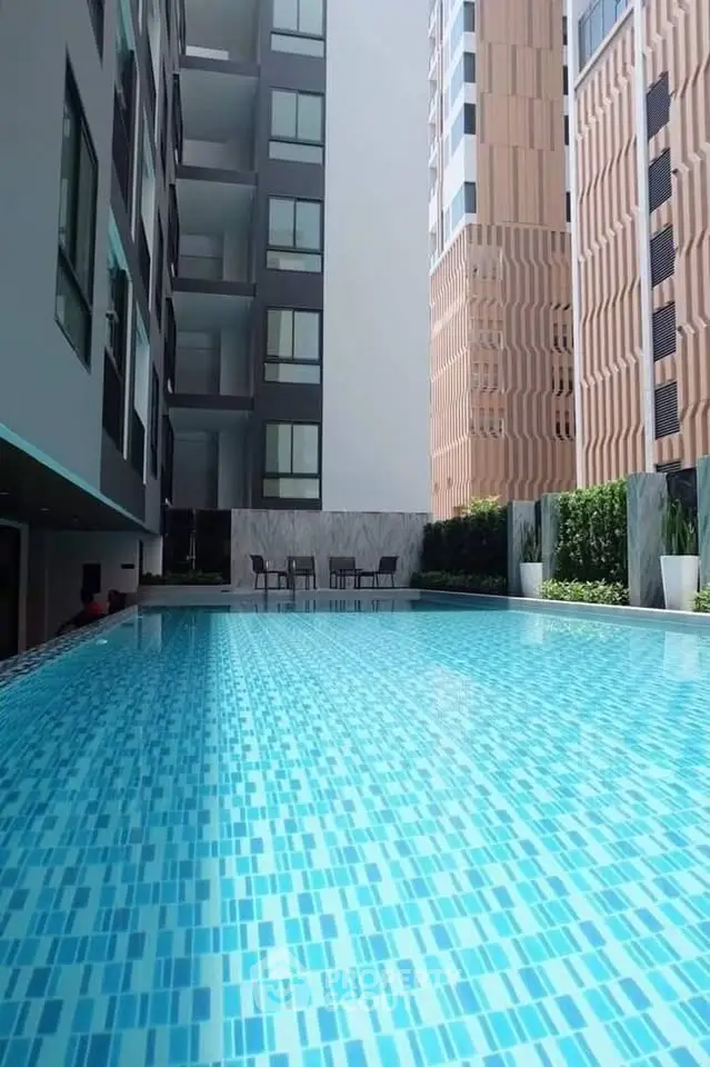 Luxurious apartment complex with a stunning outdoor pool and modern architecture.