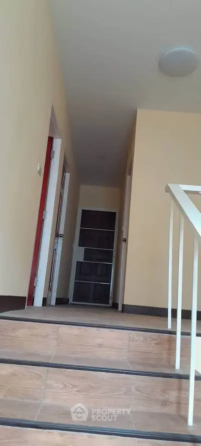 Spacious hallway with wooden flooring and modern design in a residential building.