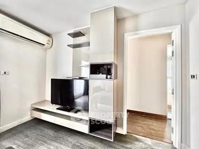 Modern living room with sleek TV unit and air conditioning in a stylish apartment.