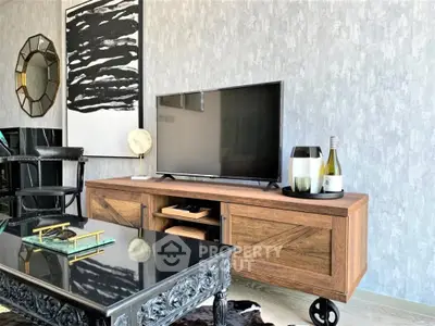 Stylish living room with modern decor and sleek furniture, featuring a large flat-screen TV and elegant wall art.
