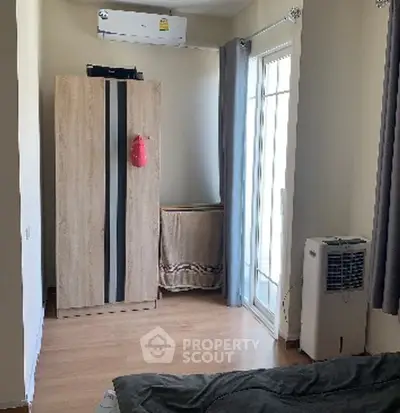 Cozy bedroom with wooden wardrobe and balcony access in modern apartment