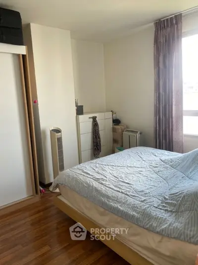 Cozy bedroom with wooden flooring and natural light