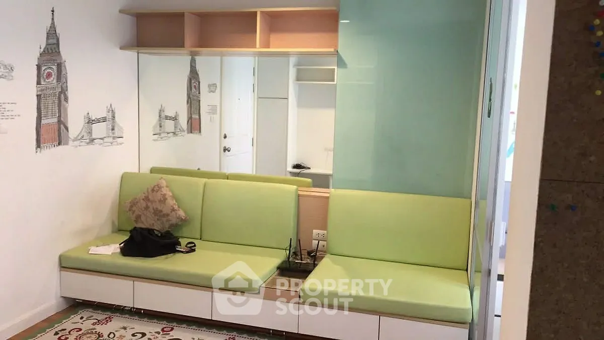 Modern living room with green seating and wall art, featuring built-in storage and a cozy atmosphere.