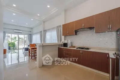 Spacious modern kitchen with open layout and dining area, featuring sleek cabinetry and ample natural light.