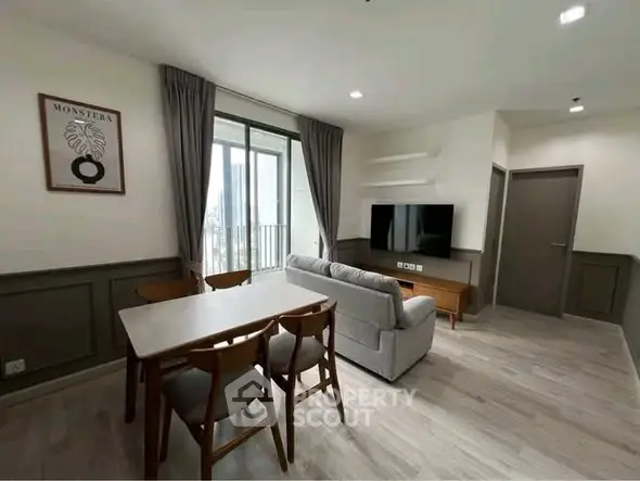 Modern living room with dining area and balcony view in stylish apartment
