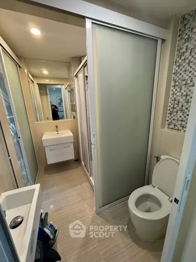 Modern bathroom with sleek design, featuring a sliding door shower and contemporary fixtures.
