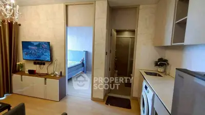 Modern apartment interior with living room, kitchen, and bedroom view, featuring sleek design and built-in appliances.