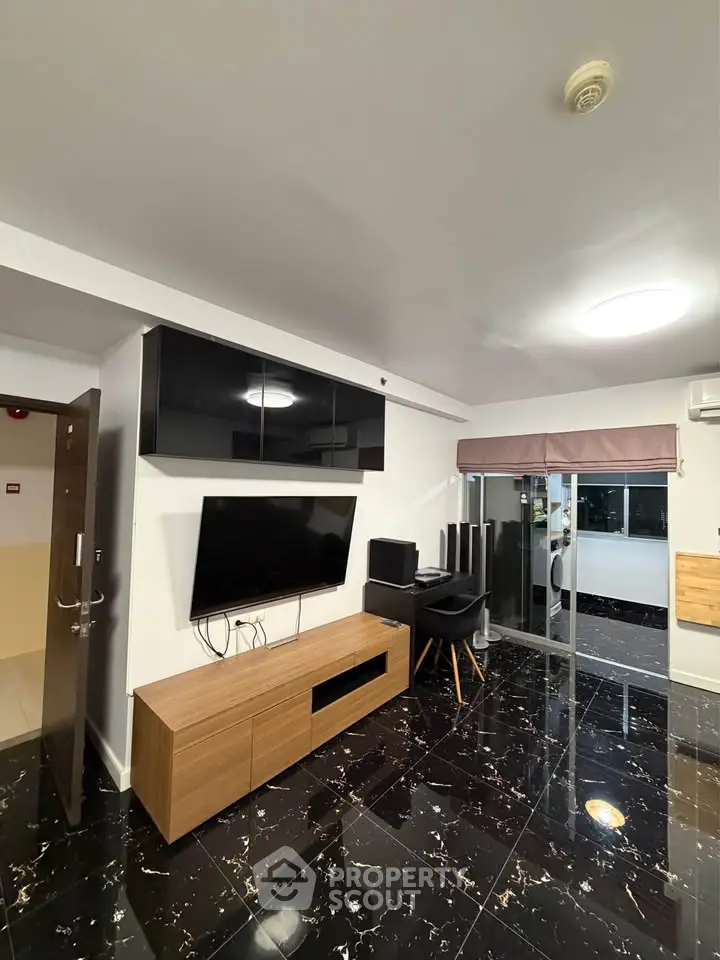Modern living room with sleek black and wood furniture, glossy marble floor, and large TV setup.
