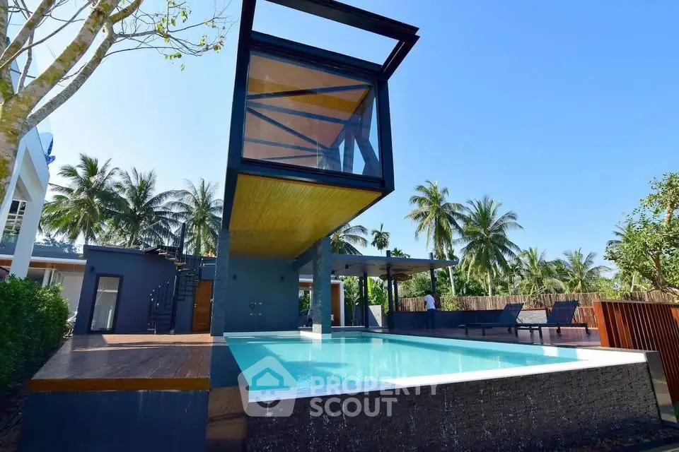 Stunning modern villa with unique elevated design and luxurious pool surrounded by tropical palm trees.