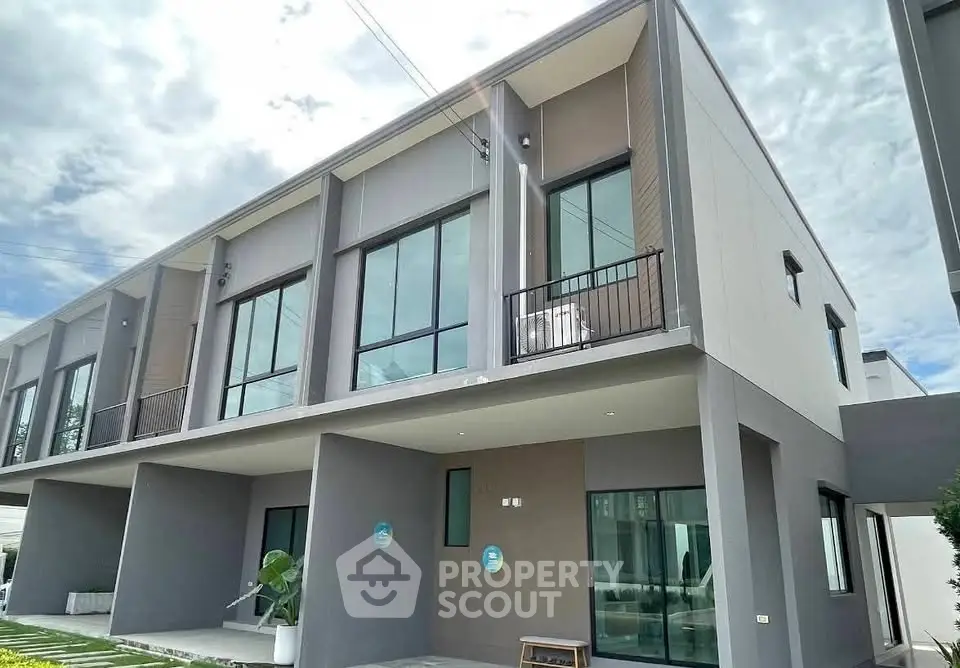 Modern two-story townhouse with large windows and minimalist design