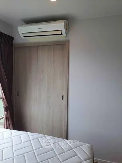 Modern bedroom with air conditioning and sliding closet doors, perfect for comfort and convenience.
