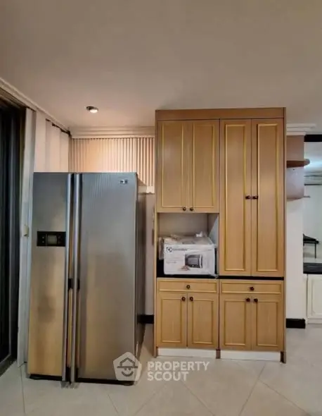 Modern kitchen with stainless steel fridge and wooden cabinets