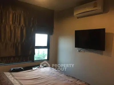 Cozy bedroom with air conditioning and wall-mounted TV, perfect for relaxation.