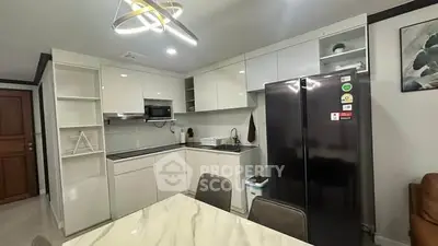 Modern kitchen with sleek appliances and elegant dining area in contemporary home.