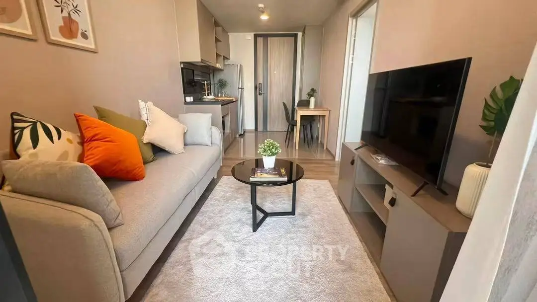 Modern living room with cozy sofa, stylish decor, and sleek TV setup in a compact apartment.
